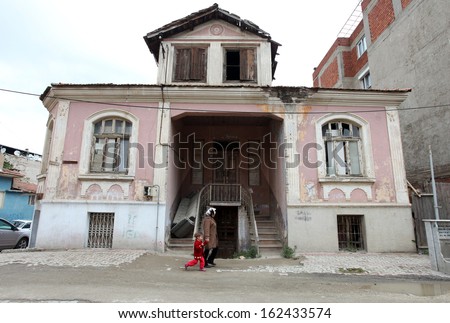 ALASEHIR, TURKEY - APRIL 27: Mom and girl walking behind old building at ancient city of Alasehir on April 27, 2011 in Manisa, Turkey. Alasehir in antiquity and the middle ages known as Philadelphia.