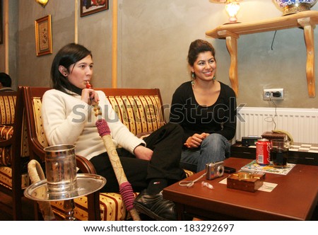 ISTANBUL, TURKEY - JANUARY 5: Turkish woman smoke hookah (Nargile) in cafe on January 5, 2008 in Istanbul, Turkey. Nargile became part of Turkish culture from the 17th century.