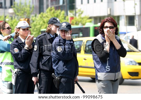 ISTANBUL, TURKEY - MAY 1: International Workers Day. Police officers exposed to tear gas on May 1, 2007 in Istanbul, Turkey. Taksim Square is the center of the protest and celebrations.