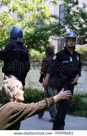 ISTANBUL, TURKEY - MAY 1: International Workers Day. A woman ask for help from Police Officers on May 1, 2008 in Istanbul, Turkey. Taksim Square is the center of the protest and celebrations.