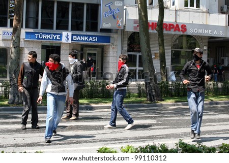 ISTANBUL, TURKEY - MAY 1: International Workers Day. Masked protesters throwing stone at Riot Police on May 1, 2008 in Istanbul, Turkey. Taksim Square is the center of the protest and celebrations.