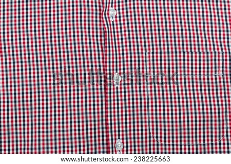 Red scottish men\'s shirt texture with buttons and pocket; Close up