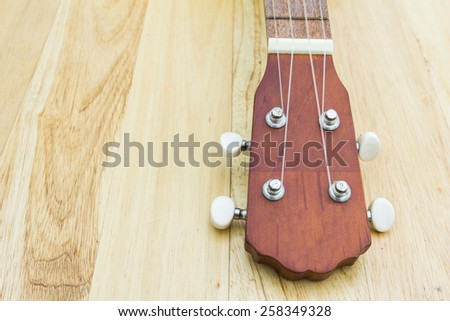 Ukulele guitar fret board on a wooden background