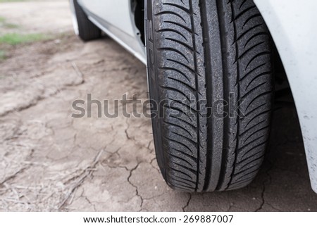 Close up of car tyre on cracked earth surface