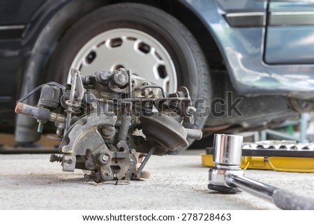 Car engine carburetor with wrench ratchet set on blue car background