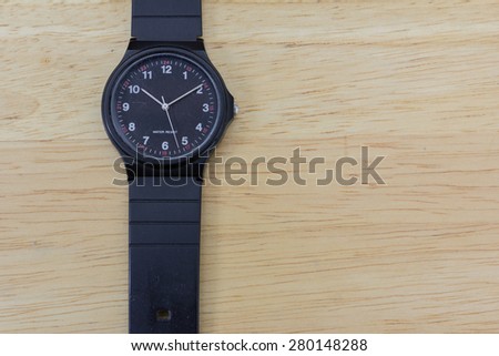 A black old wrist watch on a wooden table