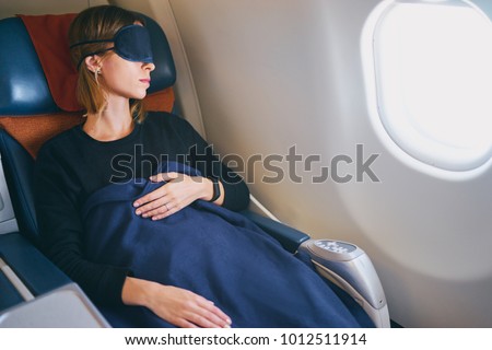 Traveling at first class. Flight with comfort. Pretty young  woman sleeping in airplane.