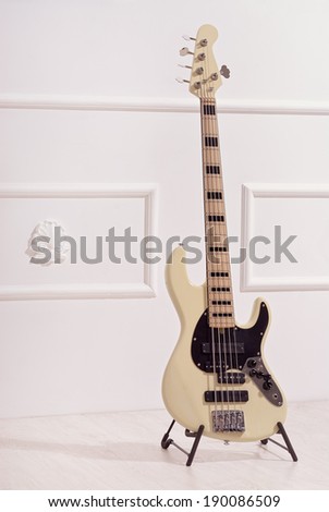 bass guitar stands near white wall