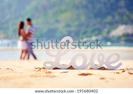 The word love and the couple in the background out of focus