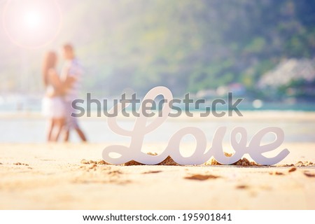 The word love and the couple in the background out of focus