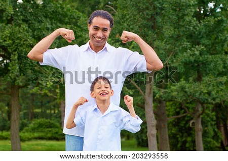 Handsome arabian man and his son showing muscles Handsome arabian man and his son showing muscles