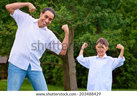 Handsome arabian man and his son showing muscles.