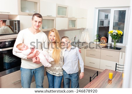 Happy family at home. Beautiful smiling caucasian family standing in the kitchen together.