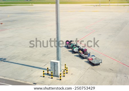 Luggage traffic on an electromobile to the plane. Freight trolleys with loaded baggage on the runway tarmac