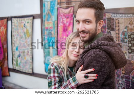 Young couple hugging outdoors in old European town. Romantic happy woman and man enjoying life and romance outside.