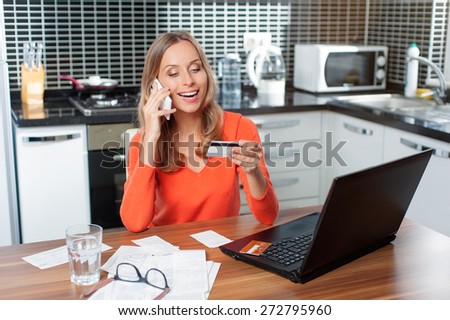 Happy Woman talking by mobile phone shopping on line with credit card and computer. Internet Shopping