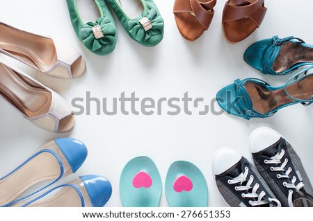 Every girl needs. Overhead of essentials for modern young woman. Different ladies shoes on white wooden background.
