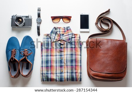 Outfit of traveler, student, teenager. Overhead of essentials for modern young person. Different objects on white wooden background.