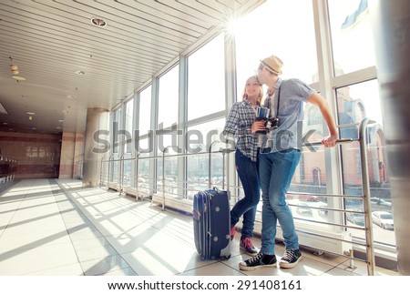 Traveling concept. Waiting for boarding. Happy loving couple in casual wear standing in airport terminal holding passport with tickets.