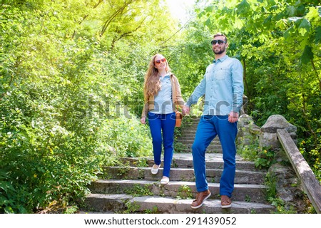 Young loving couple walking down the stairs in park together.