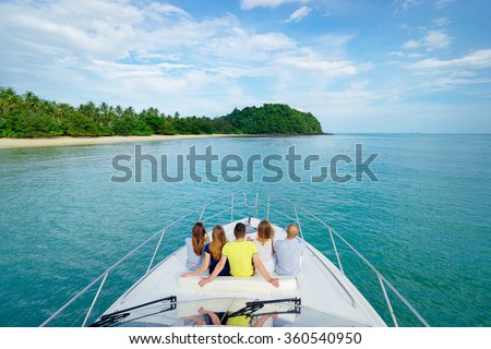Luxury traveling. Friendship and vacation. Group of young people sitting on the yacht deck sailing the sea.