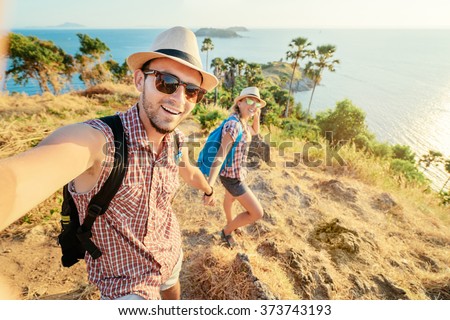 We love traveling and trekking! Adventure Selfie. Caucasian young loving couple taking selfie while they walking on mountains near the sea.