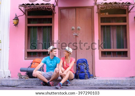 Travel and tourism. Couple of backpackers sitting together on asian street.