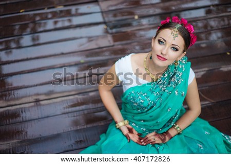 Beautiful young indian woman in traditional clothing with bridal makeup and jewelry. gorgeous  bride traditionally dressed Outdoors in India. Girl bollywood dancer in Sari and henna on hands