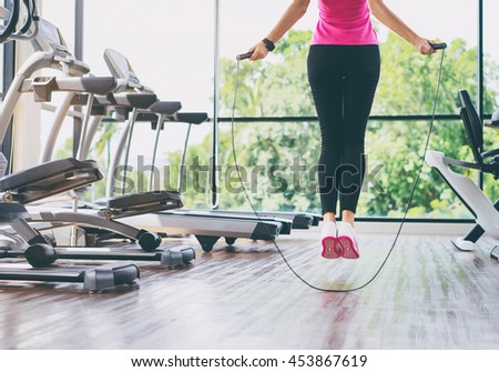 Fitness concept. Healthy lifestyle. Young slim woman jumping with skipping rope in gym.