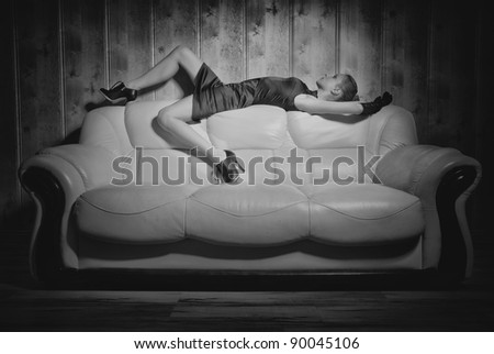 girl posing on a white sofa in a black dress