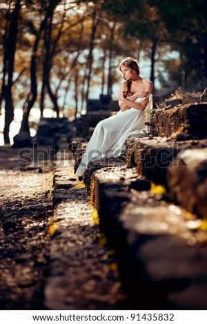 Girl in greek dress sitting on stairs