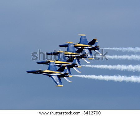 U.S. Navy Blue Angels flying in formation at an airshow.