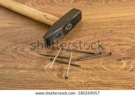 New classic hammer with long iron nails on the wood board