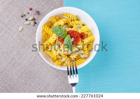 Macaroni and cheese in a bowl. Plate of Italian Pasta Fusilli with grated cheese, sauce, basil and aromatic spices.