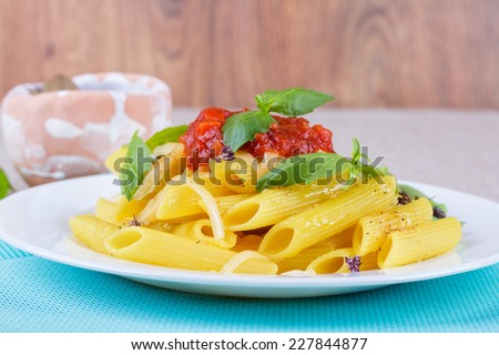 Pasta in a plate with a green basil and cheese. The culinary tradition of Italy. The second dish of pasta with cheese and tomato sauce