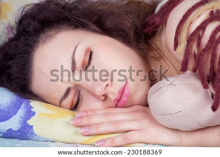 Beautiful girl sleeping soundly, seeing a bad dream. Had a terrible dream. Girl with eyes closed in bed closeup. Brunette with curly hair