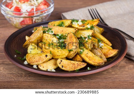 Baked potato with herbs and spices. Potato dish on the table. Baked potato and salad on the table with a napkin and fork. Hearty vegetarian lunch