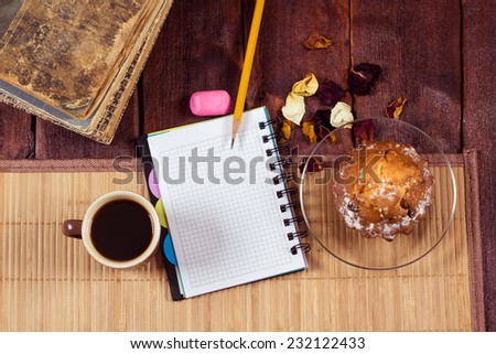 Still life of coffee, muffin, notepad and old books. Workplace literary critic, designer, editor, writer. The concept of starting a new business, a break in work.