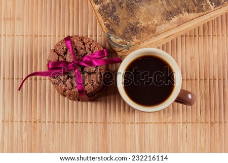 Espresso coffee with cookies and old book on the table. Snack biscuits and coffee. The pleasure of reading the book.