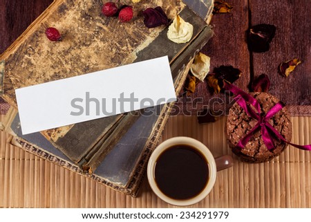 Still life with books, cup of coffee, rose petals and leaf for text.  Concept  of atmosphere of inspiration and celebration. Wooden table with books, biscuits and ristretto.