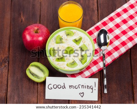 Fruit and cereal with milk for breakfast. Oatmeal with milk, apples, fresh orange juice, kiwi, note \