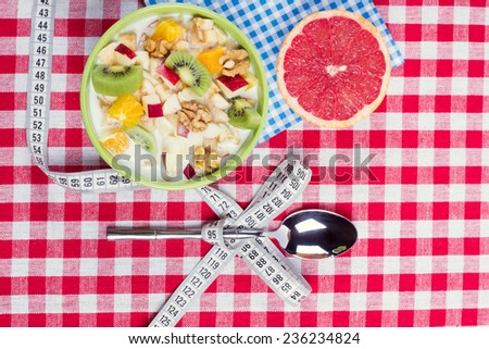 Concept of weight loss with the help of a balanced healthy diet. Vegetarian Breakfast: fruit salad with yogurt and nuts. The theme of a healthy lifestyle and balanced diet food.