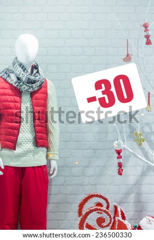 A shop window showing the sale of winter clothing. Discounts on winter clothes. Men\'s winter clothing. Mannequin in a shop window in winter clothes.