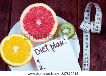 Diet plan. The concept of weight loss, wellness and healthy lifestyle. Vegetarian fruit diet. Products with low fat content. Plate with fruits and measuring tape.
