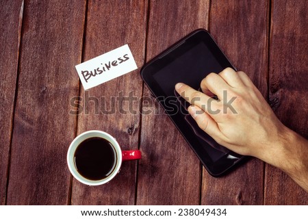 Man\'s hand on the tablet. Man\'s hand, a computer and a cup of black coffee on the table. Young businessman at work. Work with a cup of coffee. The concept of Digital Business.
