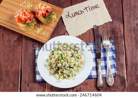 Vegetable risotto with mushrooms, bruschetta with tomatoes and cheese and cutlery. A delicious and hearty lunch. Italian cuisine. Cooking school, culinary excellence.