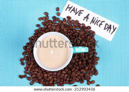 Latte coffee and beans on the background. Cup of coffee with milk and coffee beans. Note to wish a nice day. Good Morning. Morning coffee. Surprise a loved one.