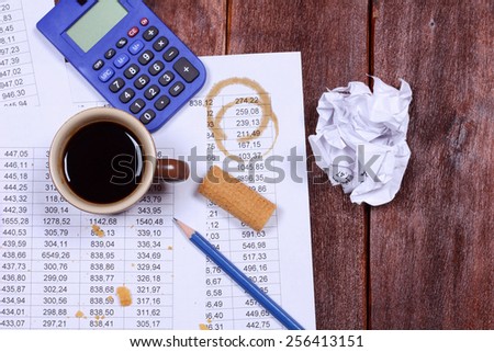 Untidy workplace. Wafers, chips, cup of coffee, crumpled paper, banner, pencil, calculator. Office desk. Accountant job. Stress at work. Start up business, working hard.