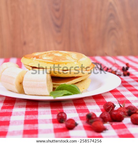 Pancake with banana on the table. Pancake delicious fluffy. American pancakes. Classic breakfast on the table. Plate with pancakes on the table.