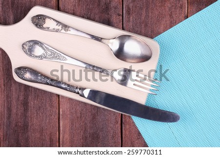 Cutlery on the table. Knife, fork and spoon on the table. Devices for food on a kitchen board, top view. Vintage cutlery, silverware.